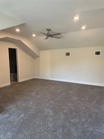 an empty room with an entryway and fan