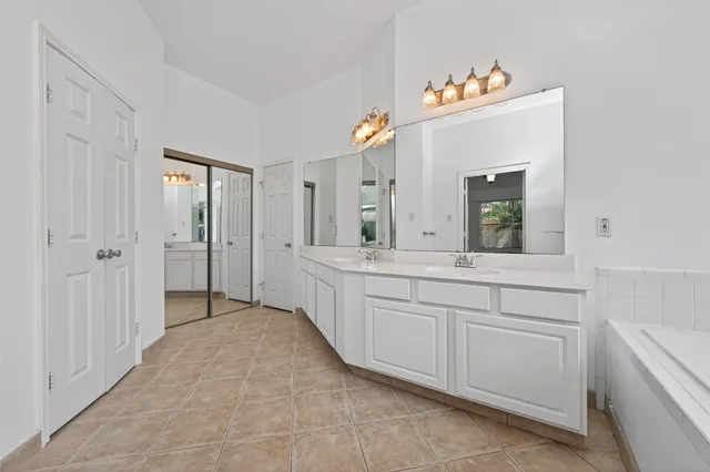 a spacious bathroom with a double vanity sink and a mirror