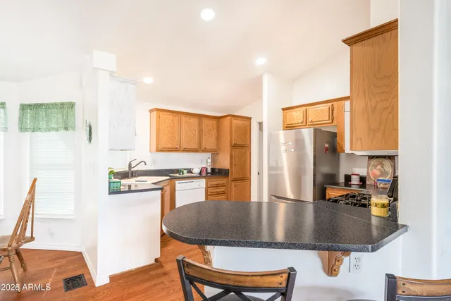 a kitchen with stainless steel appliances granite countertop a sink a stove and a refrigerator