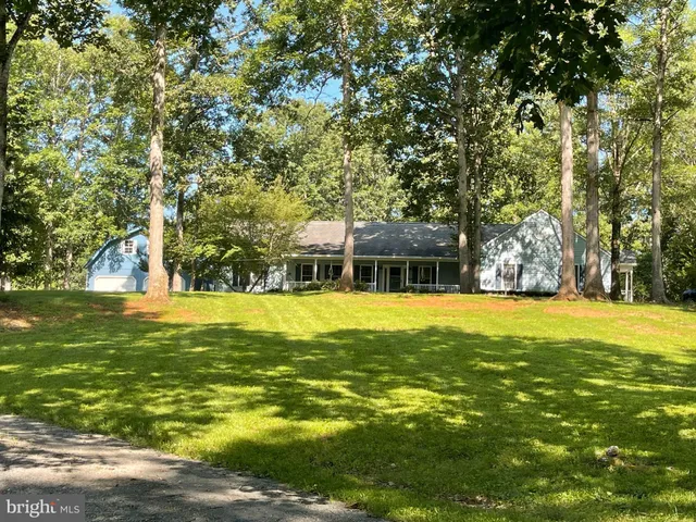 a kitchen with stainless steel appliances granite countertop a refrigerator a stove top oven a sink dishwasher and white cabinets with wooden floor