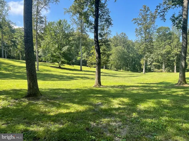 a kitchen with stainless steel appliances granite countertop a refrigerator a sink dishwasher a stove and white countertops with wooden floor