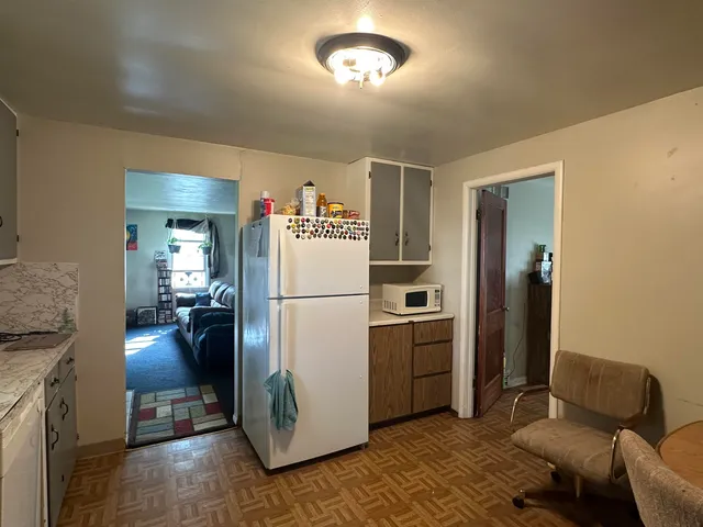 a kitchen with a refrigerator a stove and a dining table