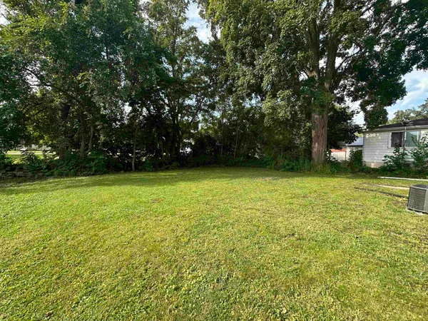 a view of yard with swimming pool and green space