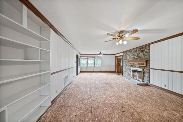 a view of an empty room with a fireplace and a window