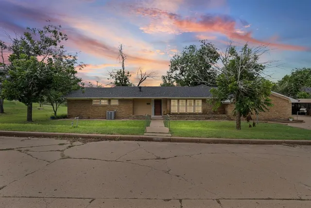 a front view of a house with a yard and a garage