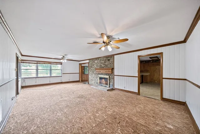 an empty room with windows and ceiling fan
