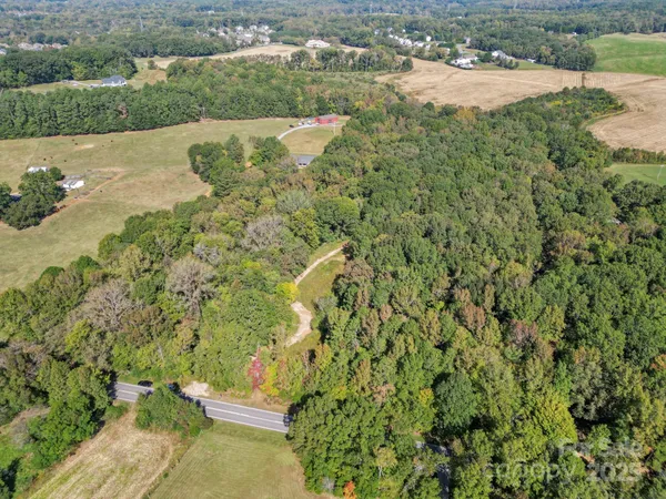 an aerial view of residential houses with outdoor space and trees
