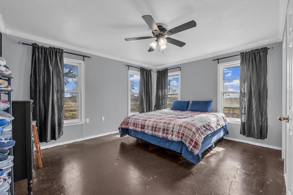 7633 South 3rd St Road Waco, TX 76706 - Photo 16 of 33 a spacious bedroom with a large bed and a chandelier