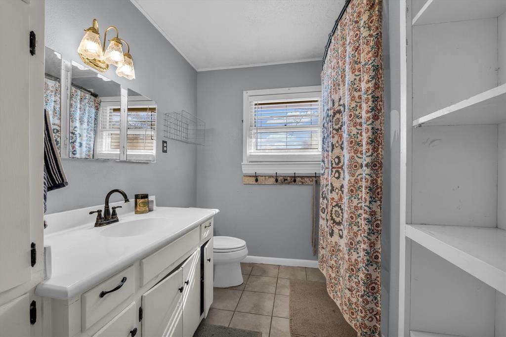 7633 South 3rd St Road Waco, TX 76706 - Photo 22 of 33 a bathroom with a sink a toilet and a mirror