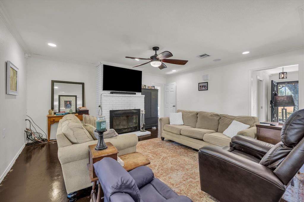 7633 South 3rd St Road Waco, TX 76706 - Photo 7 of 33 a living room with furniture a fireplace and a flat screen tv