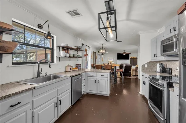 a kitchen with white cabinets and appliances
