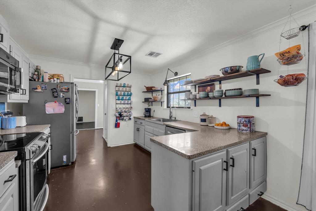 7633 South 3rd St Road Waco, TX 76706 - Photo 9 of 33 a kitchen that has a lot of cabinets a sink and wooden floor