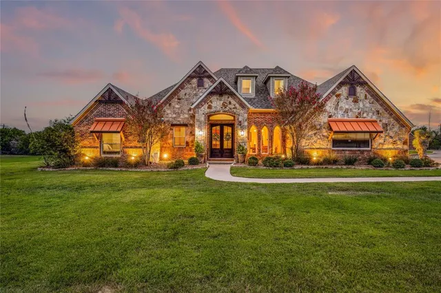 a front view of a house with a big yard and potted plants