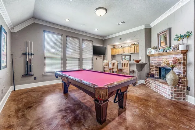 a room with pool table flat screen tv and windows