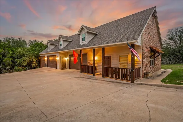 a view of a house with large windows and a small yard