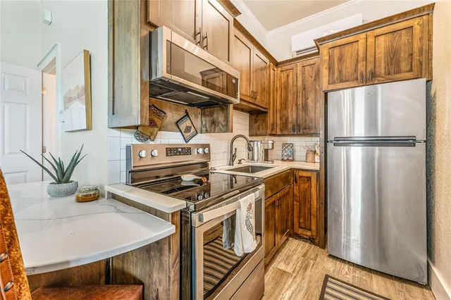 a kitchen with stainless steel appliances a stove a refrigerator and cabinets