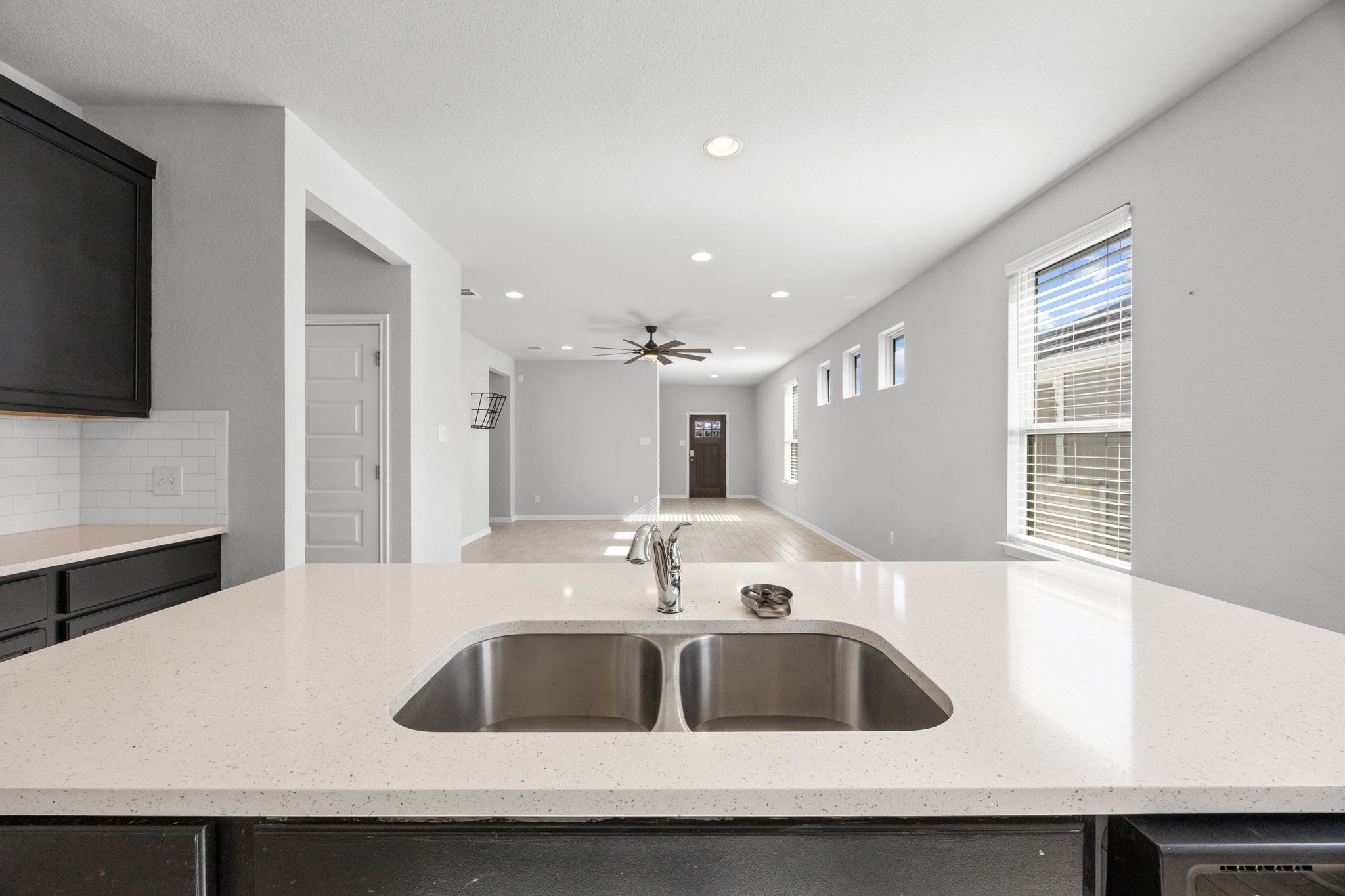 225 Unforgiven Lane Jarrell, TX 76537 - Photo 29 of 30 Kitchen featuring light stone countertops, recessed lighting, open floor plan, tasteful backsplash, and ceiling fan