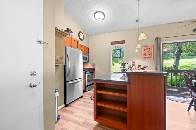 a open kitchen with stainless steel appliances granite countertop a sink and a wooden floor