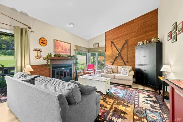 a living room with furniture a fireplace and a large window