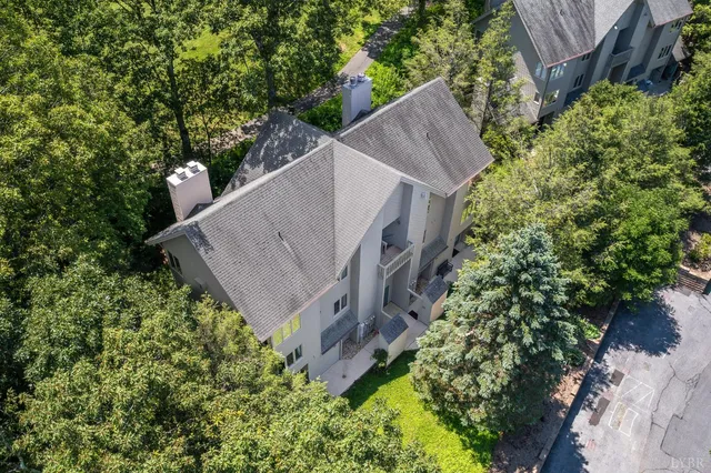 a view of a house with a yard and large trees