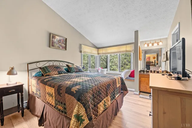 a large bedroom with a bed and a flat screen tv