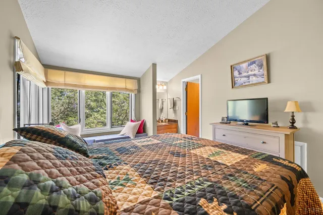 a bedroom with furniture and a large window