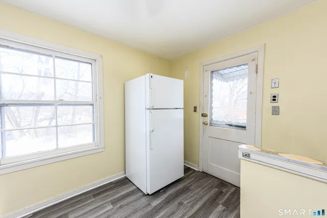 a view of a kitchen with wooden floor and electronic appliances