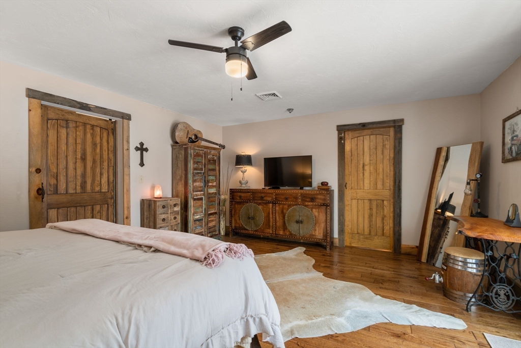 43 Ridge Way Sturbridge, MA 01566 - Photo 16 of 22 a bedroom with a bed a flat tv screen and a dresser