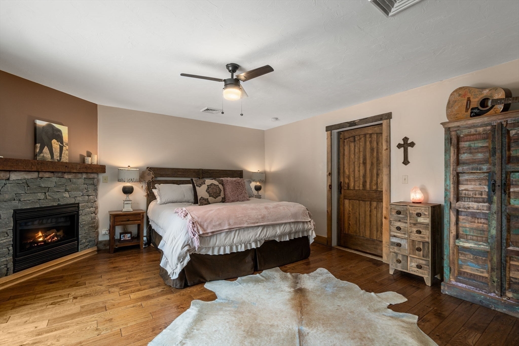 43 Ridge Way Sturbridge, MA 01566 - Photo 17 of 22 a spacious bedroom with a bed and a fireplace