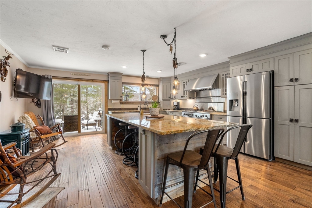 43 Ridge Way Sturbridge, MA 01566 - Photo 3 of 22 a kitchen with stainless steel appliances a dining table chairs refrigerator and sink