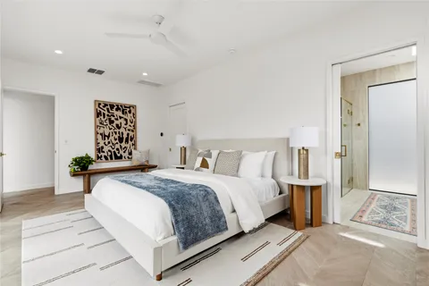 a bedroom with a large bed and a chandelier