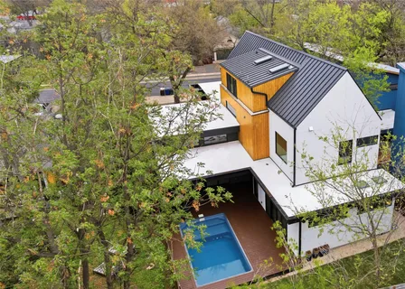 an aerial view of a house with swimming pool and porch