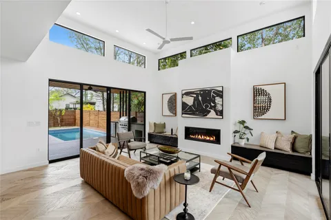 a living room with furniture large window and a fireplace