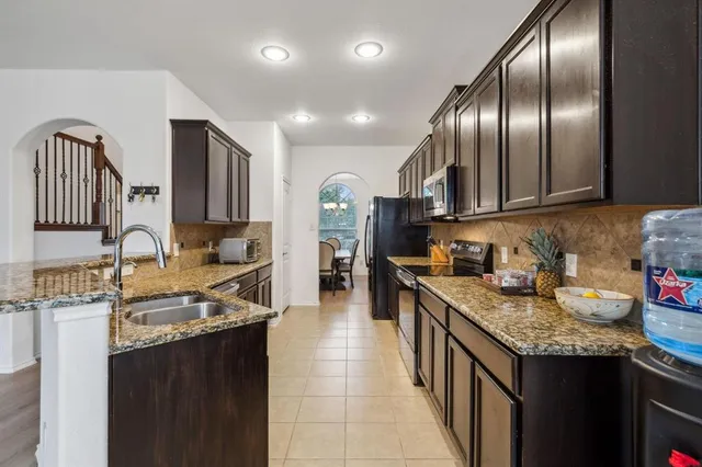 a kitchen with granite countertop stainless steel appliances and wooden cabinets