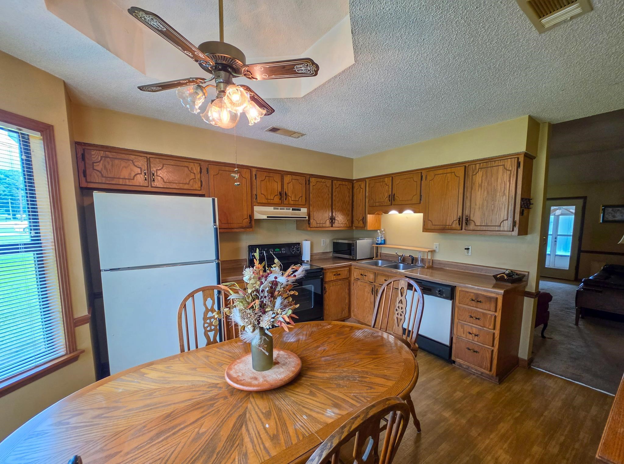 966 Beaver Road Munford, TN 38058 - Photo 21 of 32 Kitchen featuring wood-finish cabinetry, white appliances, and a double-basin stainless steel sink