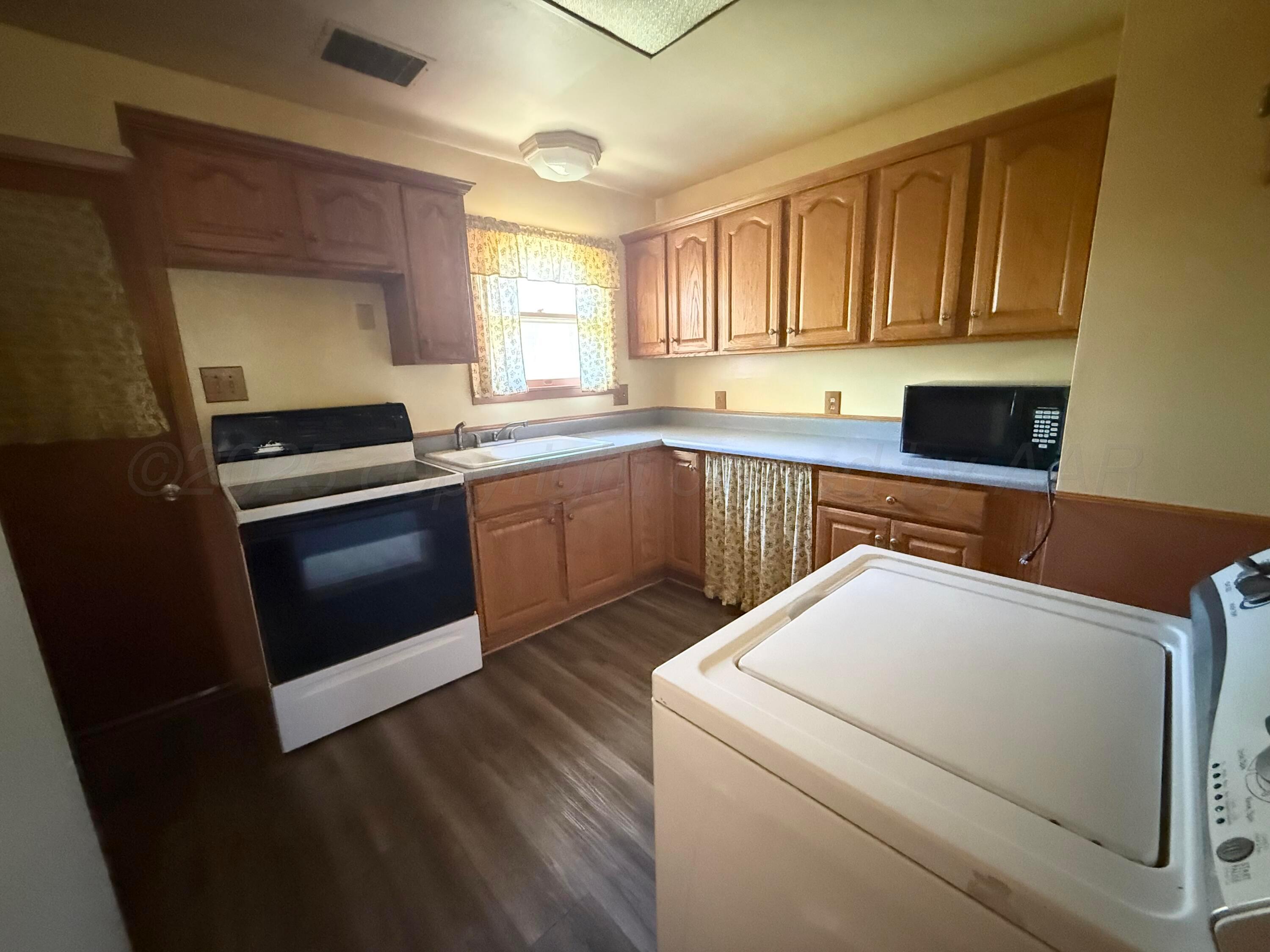 1030 Thrams Street Borger, TX 79007 - Photo 7 of 9 a kitchen with a stove microwave and sink