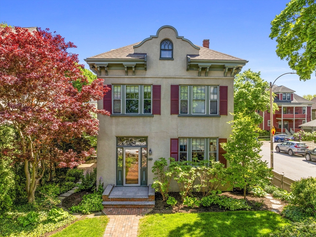 82 Perkins Street Boston, MA 02130 - Photo 1 of 31 a view of a brick house with a large windows and a yard with plants and large trees
