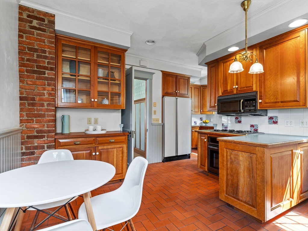 82 Perkins Street Boston, MA 02130 - Photo 8 of 31 a kitchen with stainless steel appliances granite countertop a kitchen island hardwood floor sink stove dining table and chairs