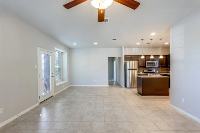a large kitchen with stainless steel appliances kitchen island granite countertop a refrigerator and a stove top oven