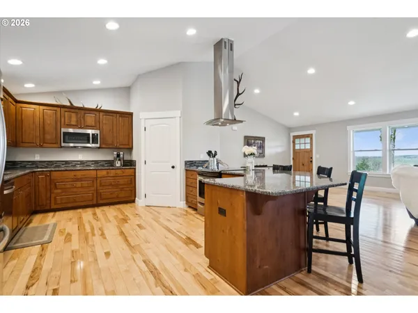 a large kitchen with stainless steel appliances kitchen island granite countertop a sink and cabinets