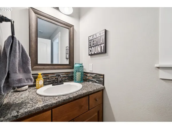 a bathroom with a granite countertop sink and a mirror
