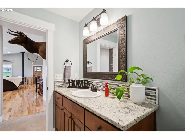 a en suite bathroom with a granite countertop sink and a mirror