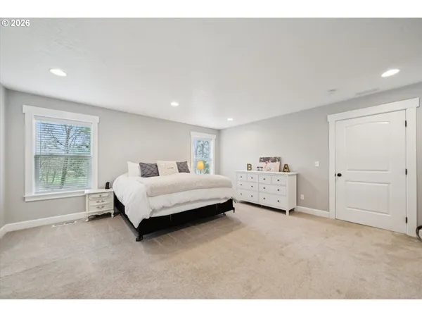 a spacious bedroom with a bed and a window