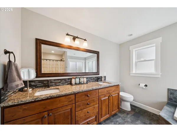 a bathroom with a granite countertop sink and a large mirror