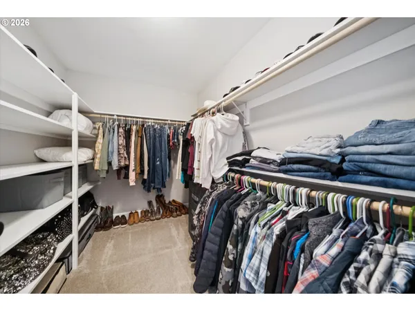 a view of walk in closet with clothes and shoes