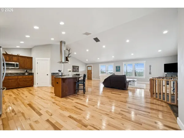a kitchen with stainless steel appliances kitchen island granite countertop a refrigerator and microwave