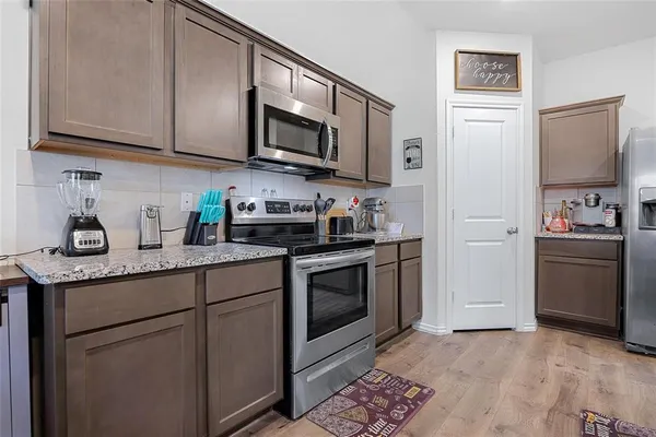 a kitchen with stainless steel appliances granite countertop a refrigerator sink and stove top oven