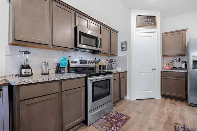 a kitchen with stainless steel appliances granite countertop a refrigerator sink and stove top oven
