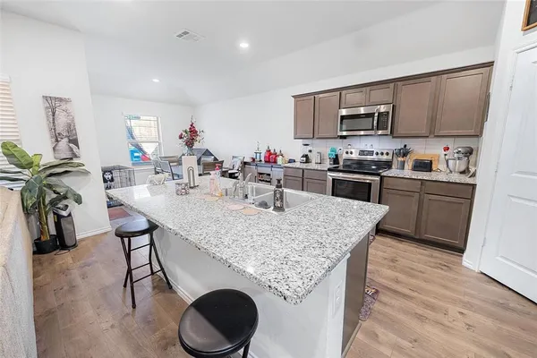 a kitchen with sink a microwave and cabinets