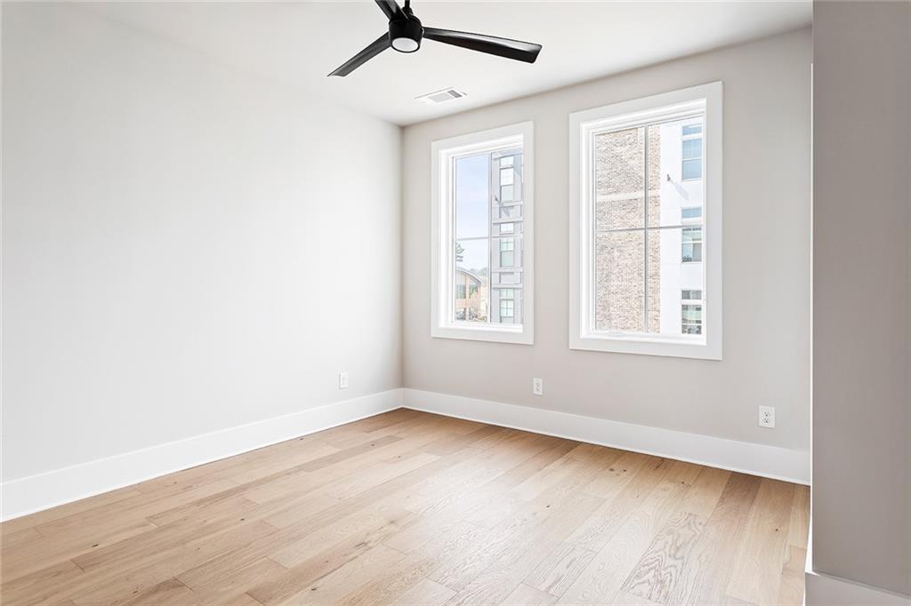 7150 Summit Place Alpharetta, GA 30009 - Photo 11 of 33 an empty room with wooden floor fan and windows